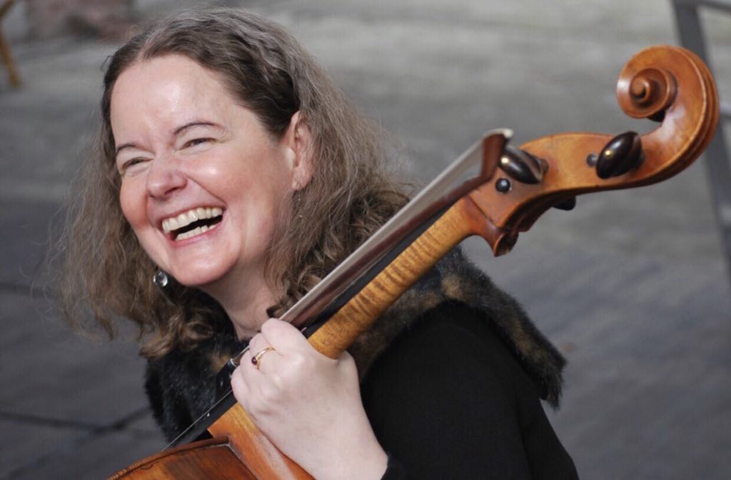 Tess Remy-Schumacher smiling with her cello.